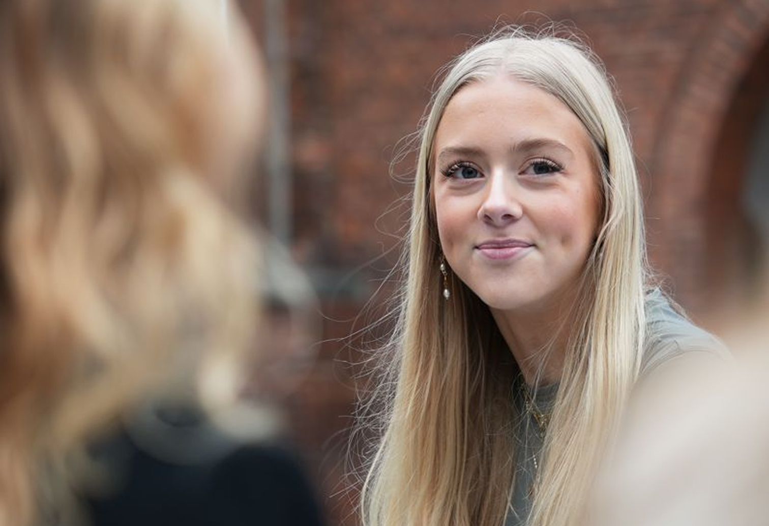 en pige som kigger ind i kamraet og smiler